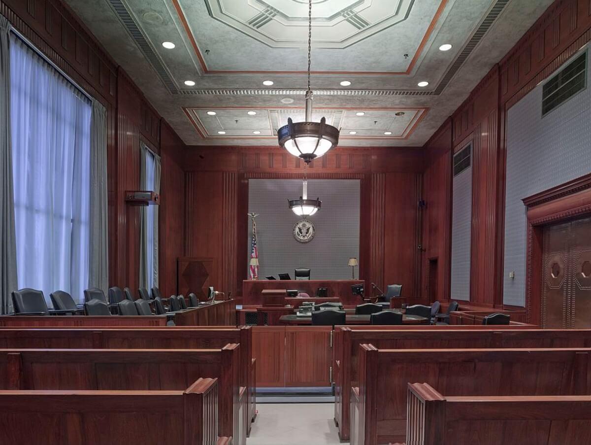 Wood-paneled courtroom with judge's bench, jury seats, and gallery, illustrating bench trial versus jury trial choices.