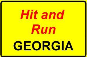 Yellow road sign with bold red and black text reading 'Hit and Run Georgia' warning about Georgia hit and run laws